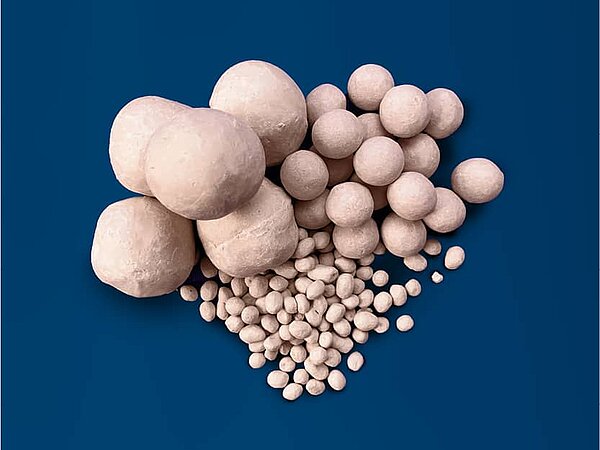 Verfüllmaterial in Form von Tonkugeln liegt auf blauen Hintergrund.