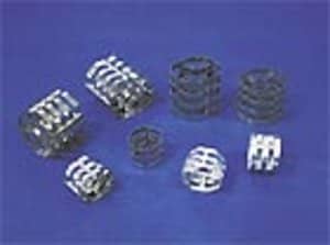 Mehrere zylinderförmige Füllkörper aus Metall liegen auf blauen Untergrund.