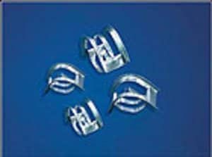 Vier Füllkörper aus Metall liegen auf einem blauen Untergrund.