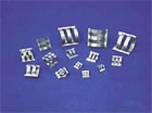 Mehrere Füllkörper aus Metall liegen auf blauen Untergrund.